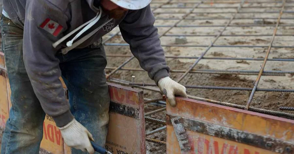 Worker installing concrete forms with rebar foundation